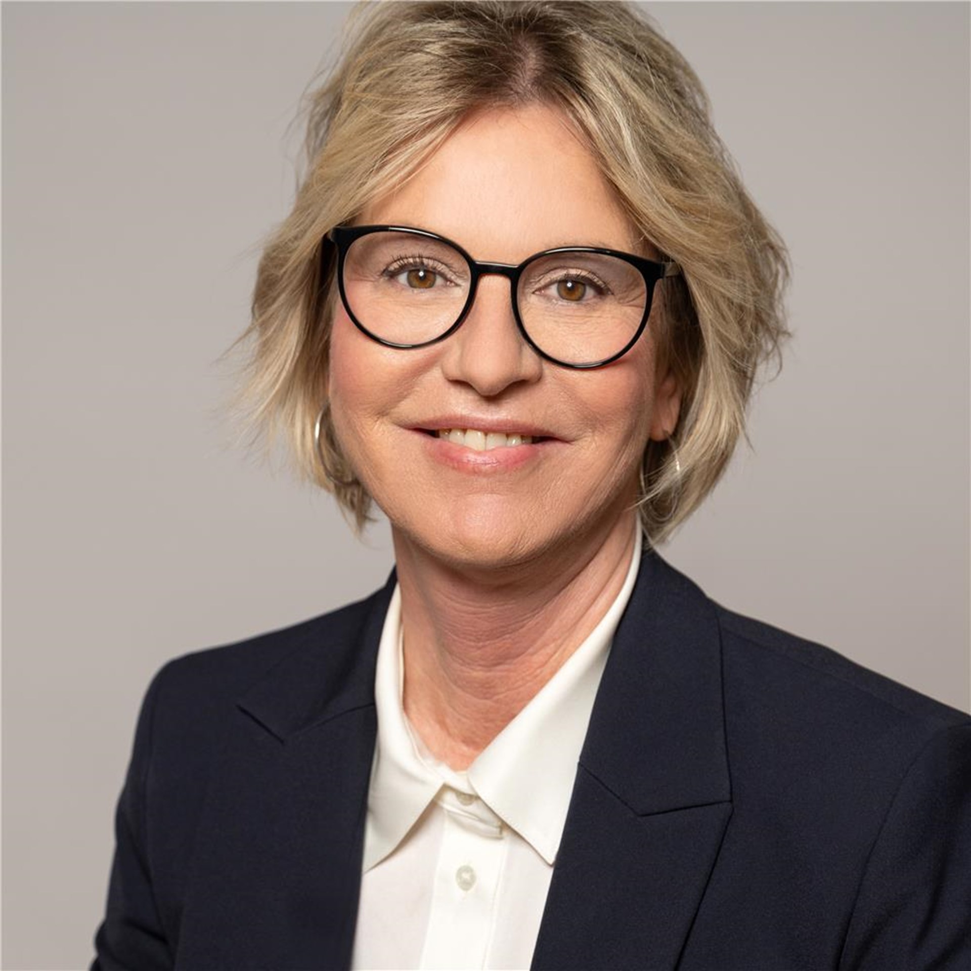 Wagner, Sabine
lächelnde mittelblonde Frau mit Brille, schwarzes Oberteil mit darunterliegender weißen Bluse